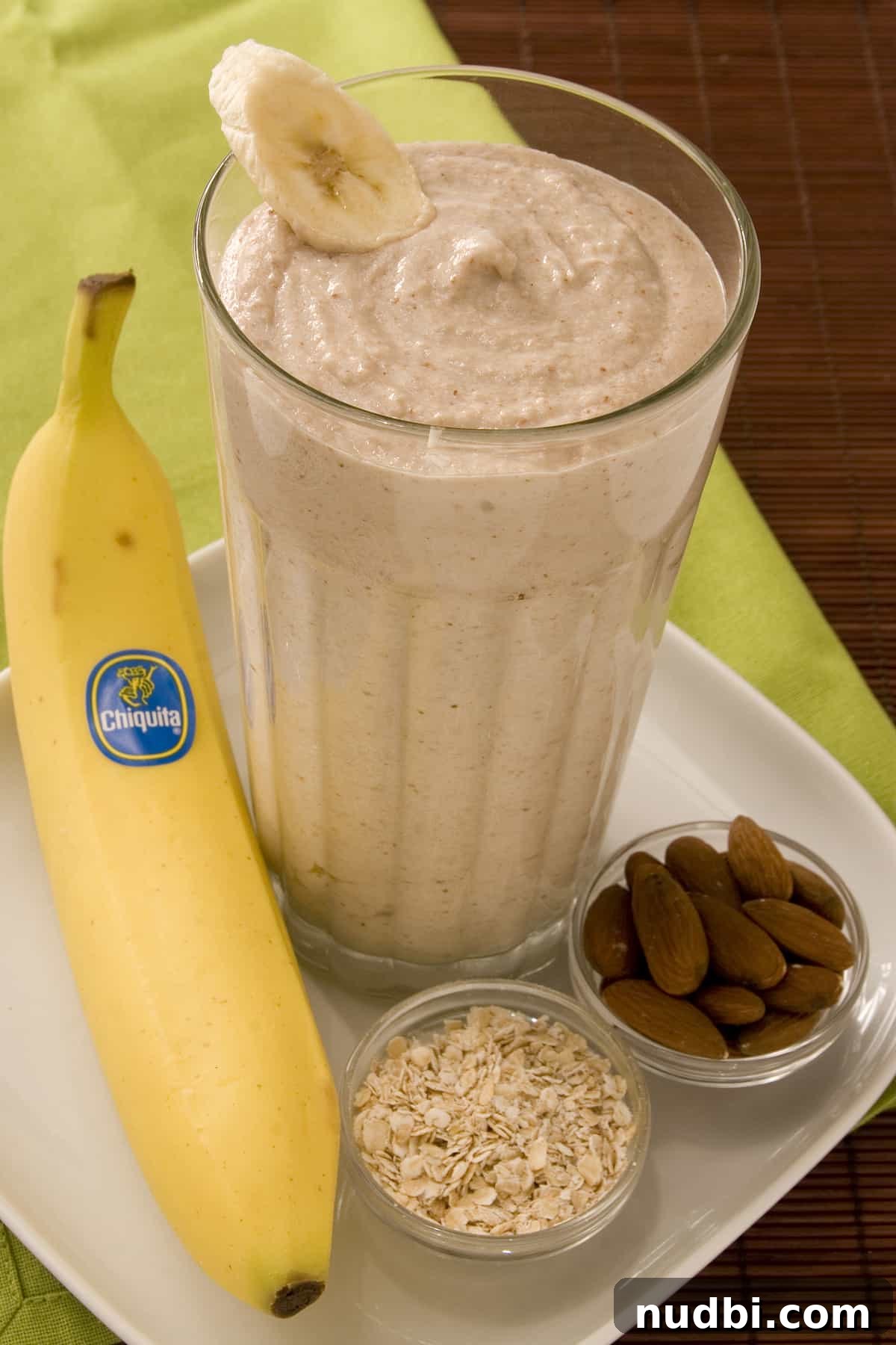 DIY Smoothie Bar Printable and Recipe Kit 2 A tall glass of quick banana oatmeal smoothie topped with fresh banana slices.