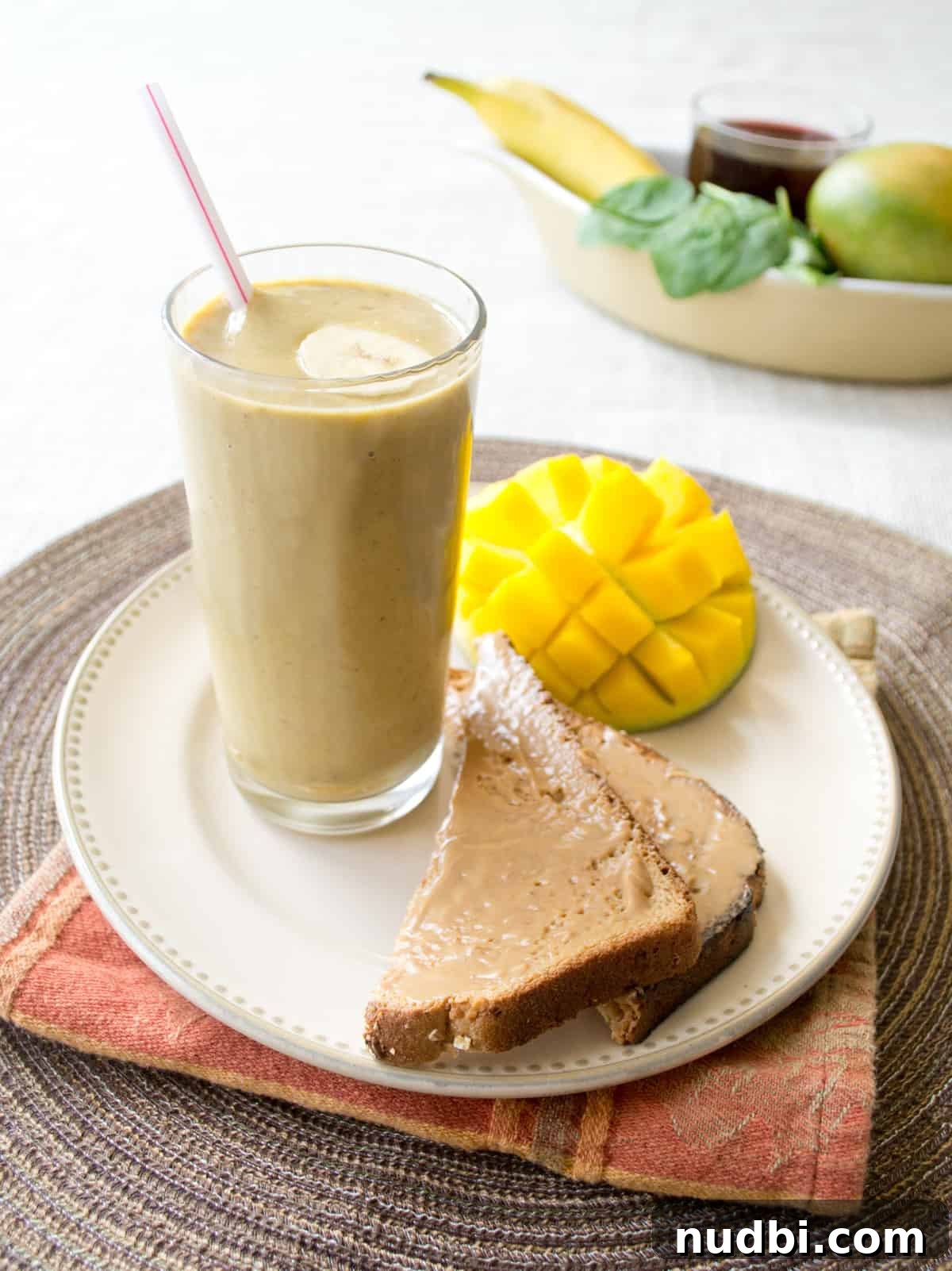 DIY Smoothie Bar Printable and Recipe Kit 12 A tropical fruit and pumpkin pie smoothie in a glass with a cinnamon stick.