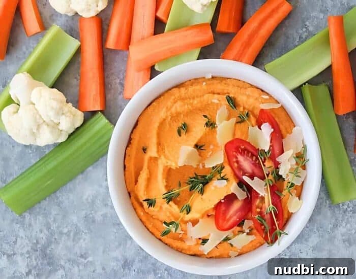 Sizzling Summer BBQ Inspirations 7 Freshly made hummus with roasted tomatoes, served with colorful vegetable sticks and pita bread, a healthy cookout snack.