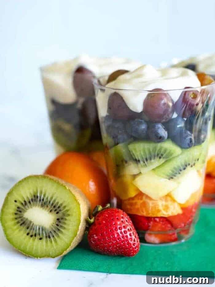 Colorful rainbow fruit and yogurt parfait layered in a glass