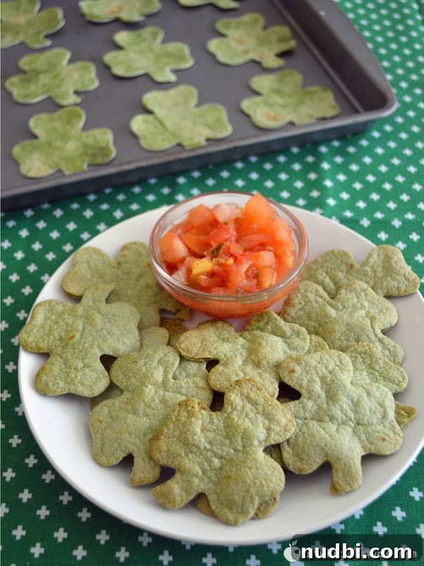 Shamrock-shaped spinach chips with green salsa in a bowl