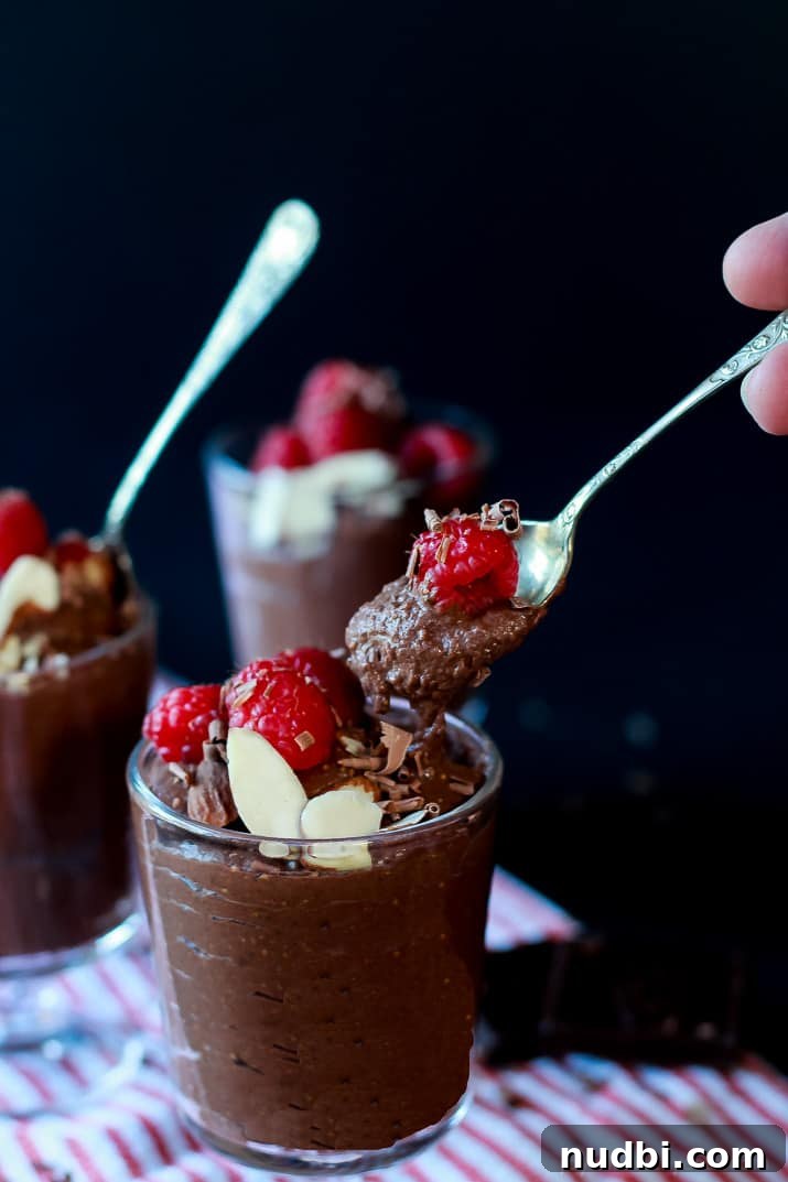 Dark chocolate chia pudding layered in a glass with berries.