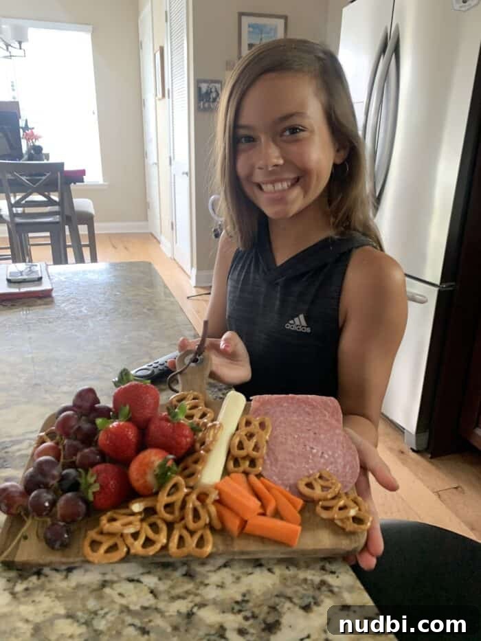 A colorful vegetable-focused snack board, featuring a variety of cut vegetables, dips, and complementary items arranged for children.