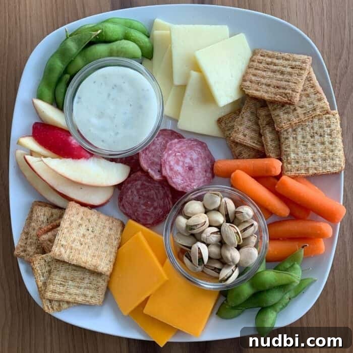 A vibrant fruit snack board showcasing a variety of fresh and dried fruits, along with a dip, arranged for healthy snacking.