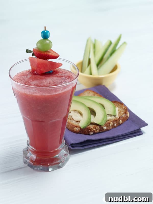 Vibrant splash of fun fruit smoothie in a tall glass.
