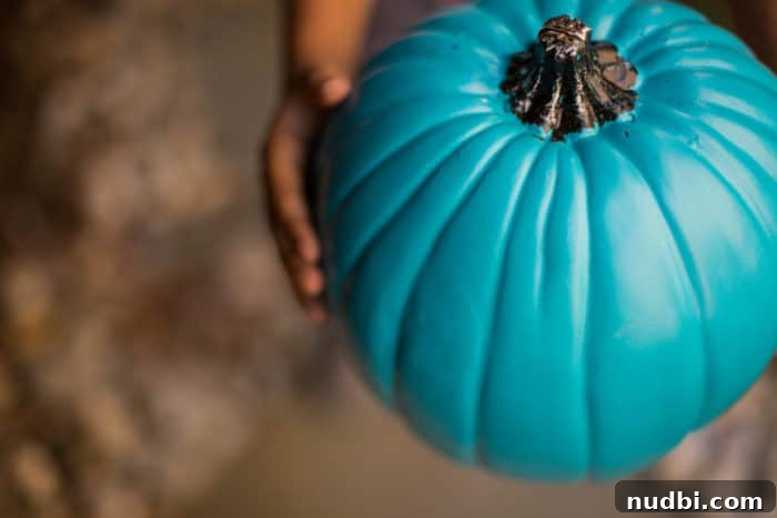 Making Halloween Magic: Allergy-Friendly Fun with the Teal Pumpkin Project 3 A child holding a teal pumpkin with various non-food treats scattered around.