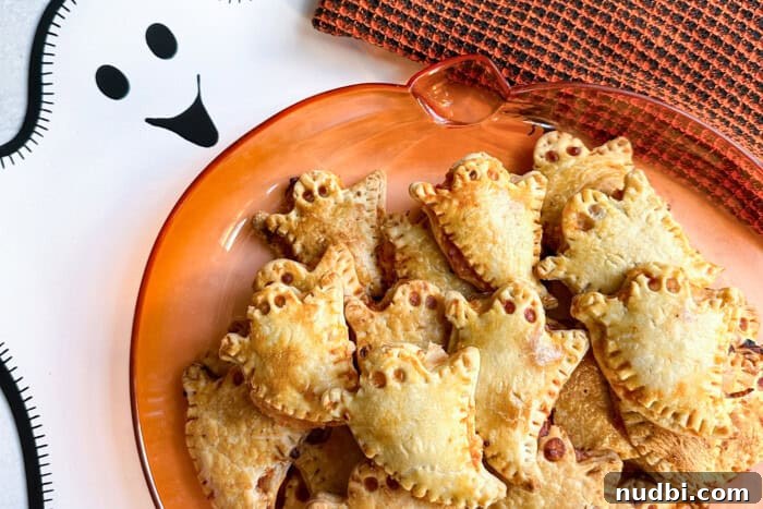 Wicked Treats and Spooky Eats 6 Ghost-shaped pizza snacks on a pumpkin tray for Halloween