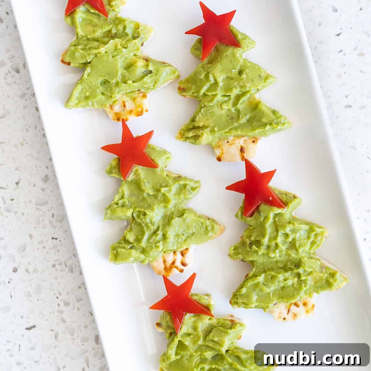 Guac Your Holidays Unexpected Festive Recipes 4 Cute Christmas Tree Mini Pizzas topped with vibrant guacamole.