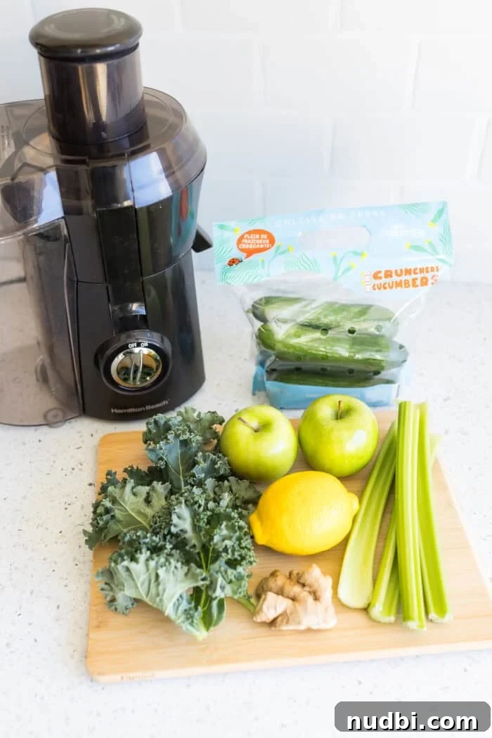 Green juice ingredients and a juicer machine on a counter