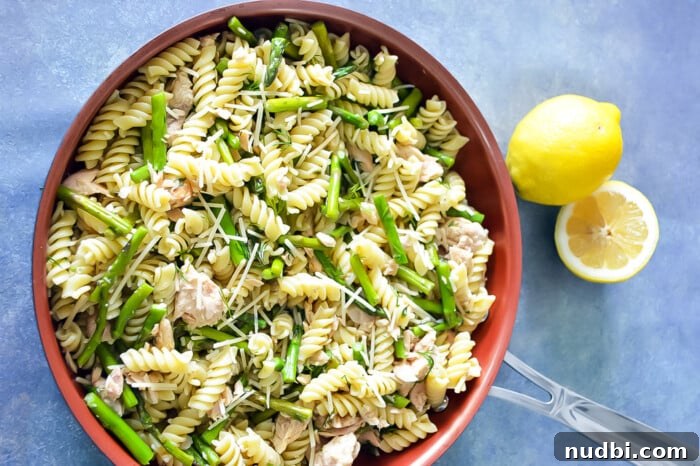 Fresh asparagus spears arranged on a cutting board with herbs and lemon.