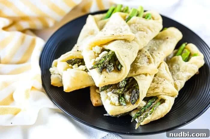 Golden-brown asparagus puff pastry bundles on a serving platter.