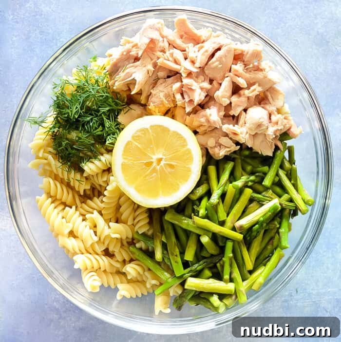 Lemon Dill Salmon pasta bowl with Asparagus, garnished with fresh dill.