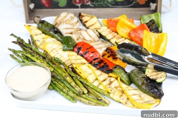 A colorful dish of grilled asparagus, bell peppers, zucchini, and cherry tomatoes.