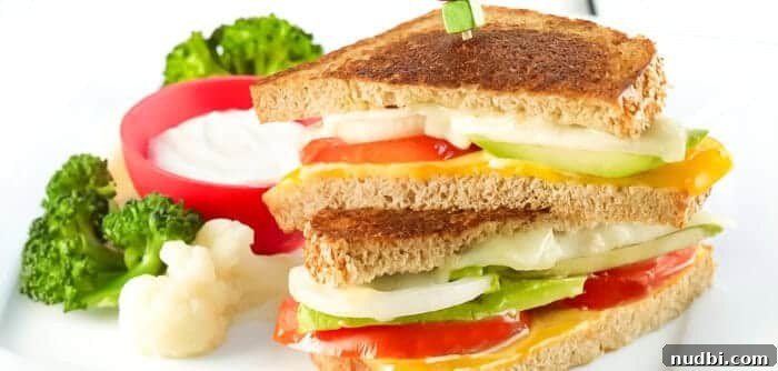 A simple yet delightful Easy Cheesy Tomato Sandwich, sliced to reveal juicy tomatoes and melted cheese.