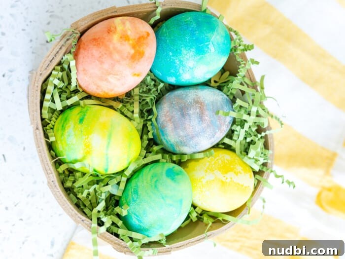 Vibrant marbled Easter eggs dyed using the Cool Whip method, arranged in a basket.
