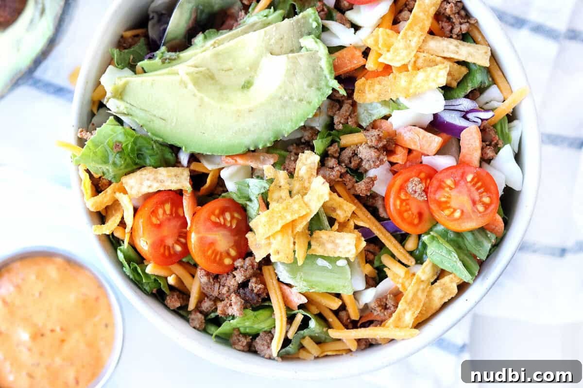 A healthy and colorful taco salad bowl featuring a variety of fresh ingredients, perfect for reinventing Cinco de Mayo leftovers.