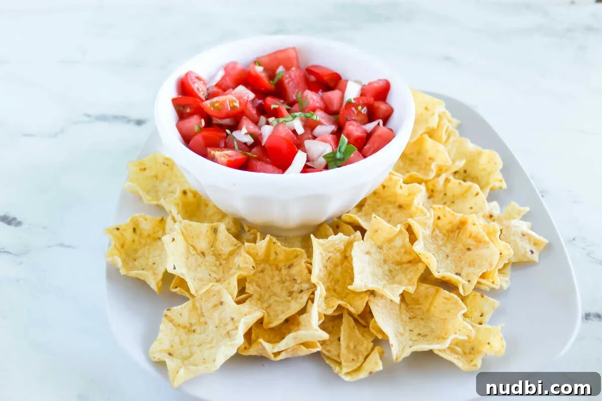 Fresh watermelon salsa with tortilla chips Fresh watermelon salsa with tomatoes, onion, and basil, surrounded by tortilla chips.