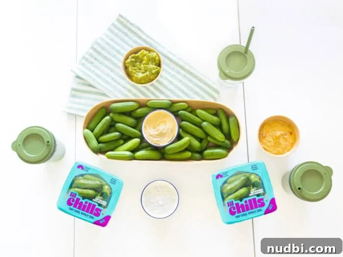 A child happily dipping a Nature Fresh Farms Lil' Chills mini cucumber into a small container of dip.