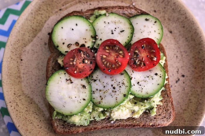 Elevate Your A.M. Plate 5 Avocado toast topped with grape tomatoes and zucchini, a fresh and healthy breakfast option.