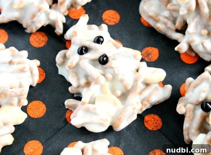 White chocolate ghost haystacks with candy eyes on a white plate.