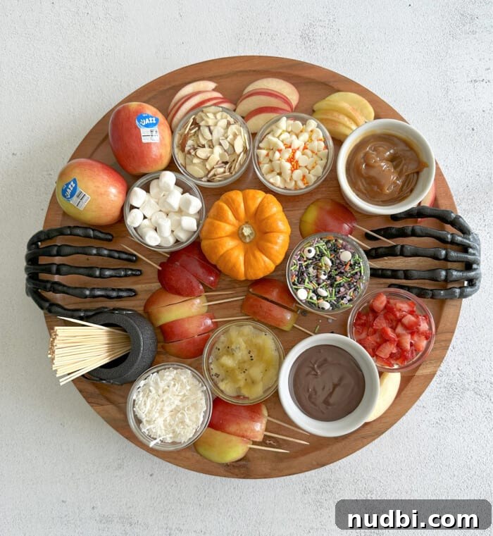 An apple charcuterie board featuring various apple slices, nuts, and dips.