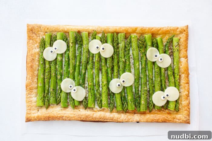 Flatbread with cheese and asparagus, possibly shaped or decorated for Halloween.