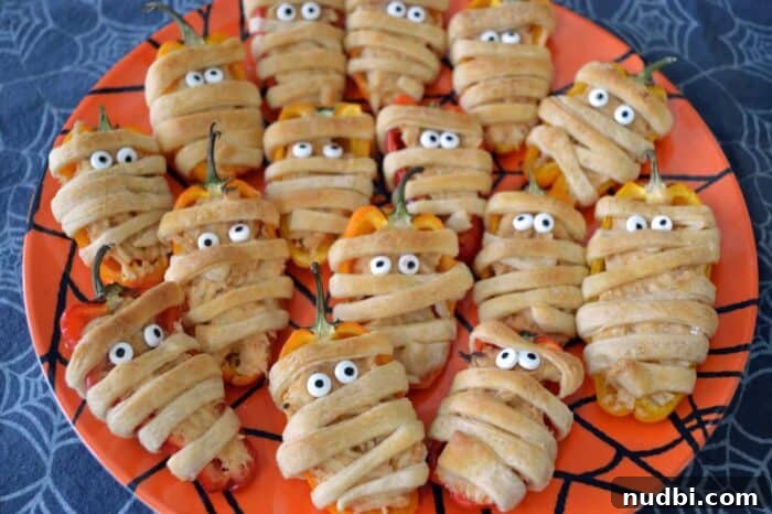Close-up of taco-stuffed mini sweet pepper mummies with candy eyes.