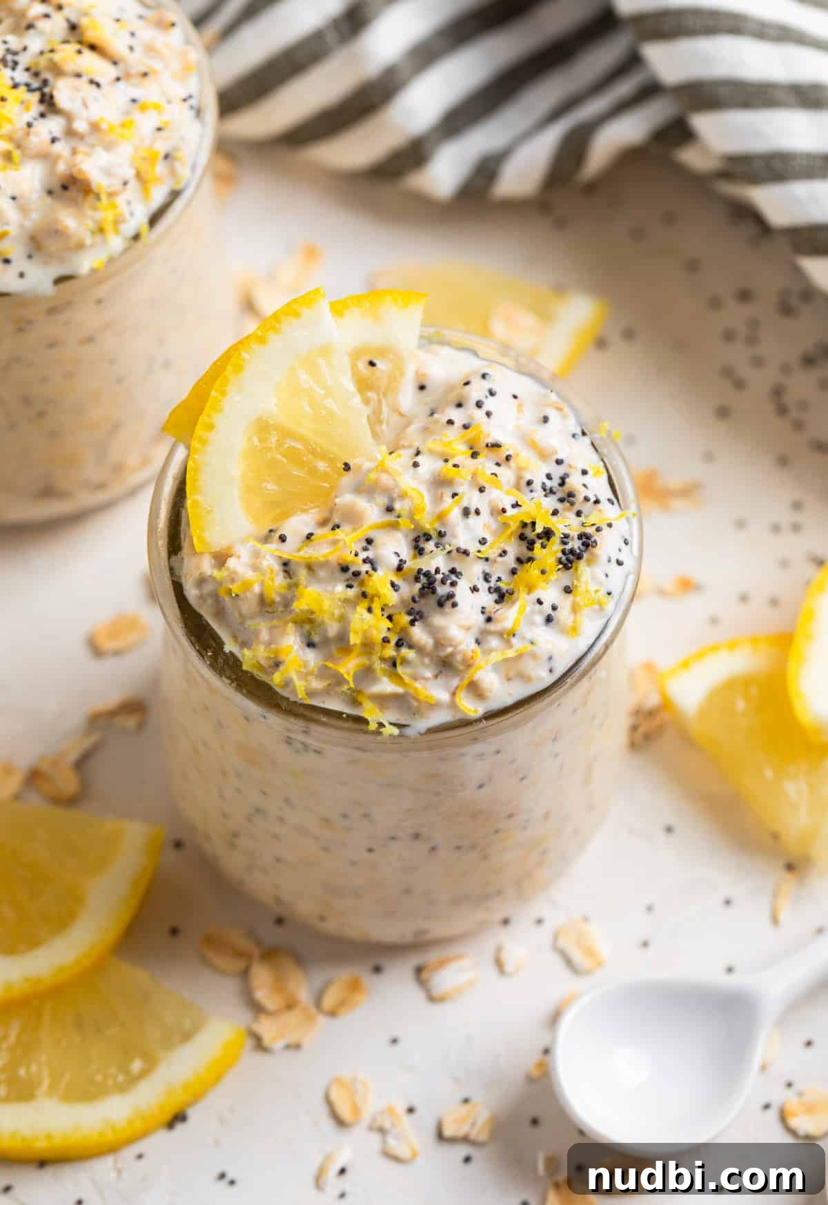 Lemon Poppy Seed Overnight Oats Recipe for Bright Morning Meals 2 Lemon poppy seed overnight oats in glass jar with lemon zest and poppy seeds on top.