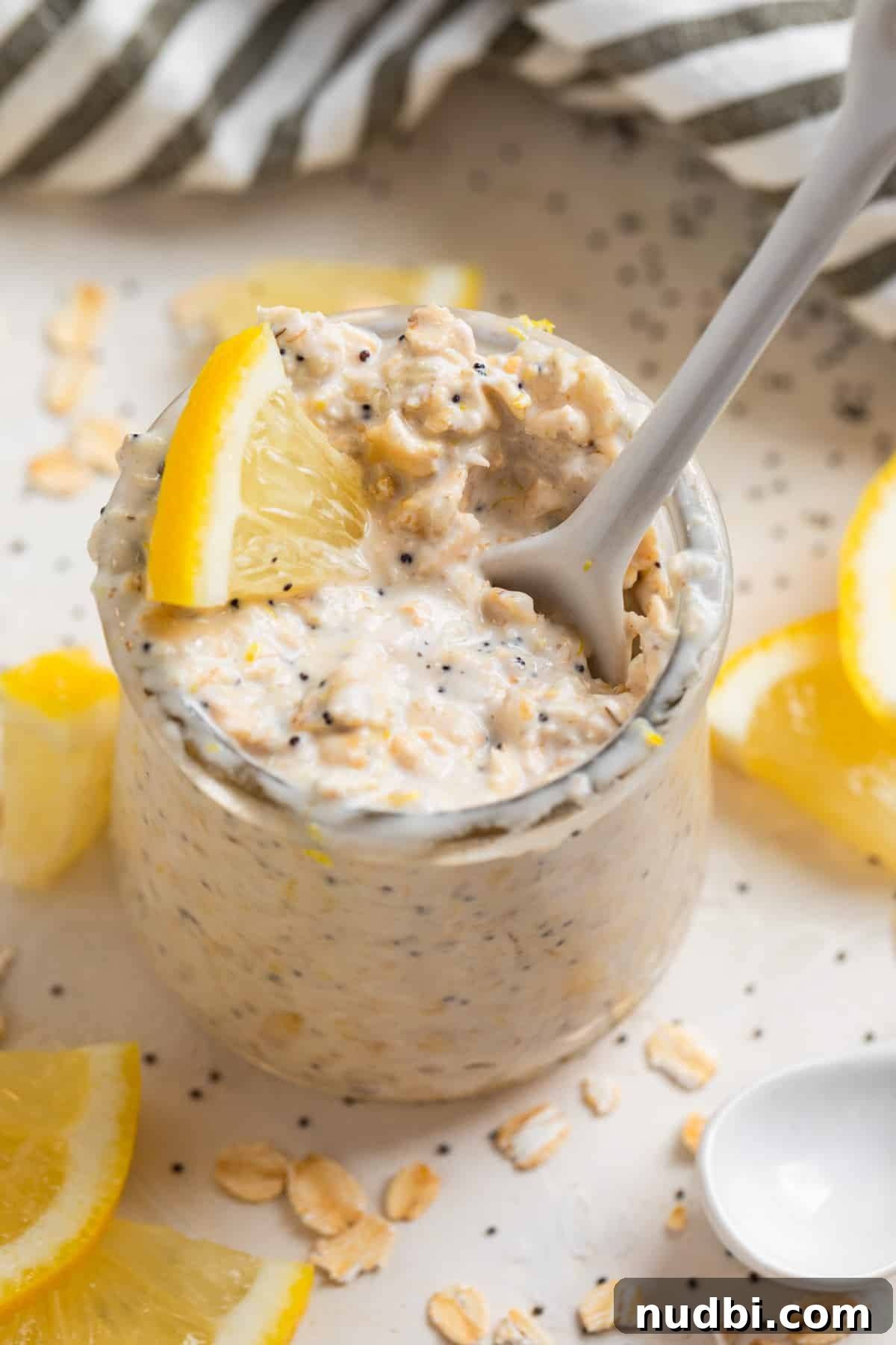 Lemon Poppy Seed Overnight Oats Recipe for Bright Morning Meals 6 White ceramic spoon scooping into oatmeal.