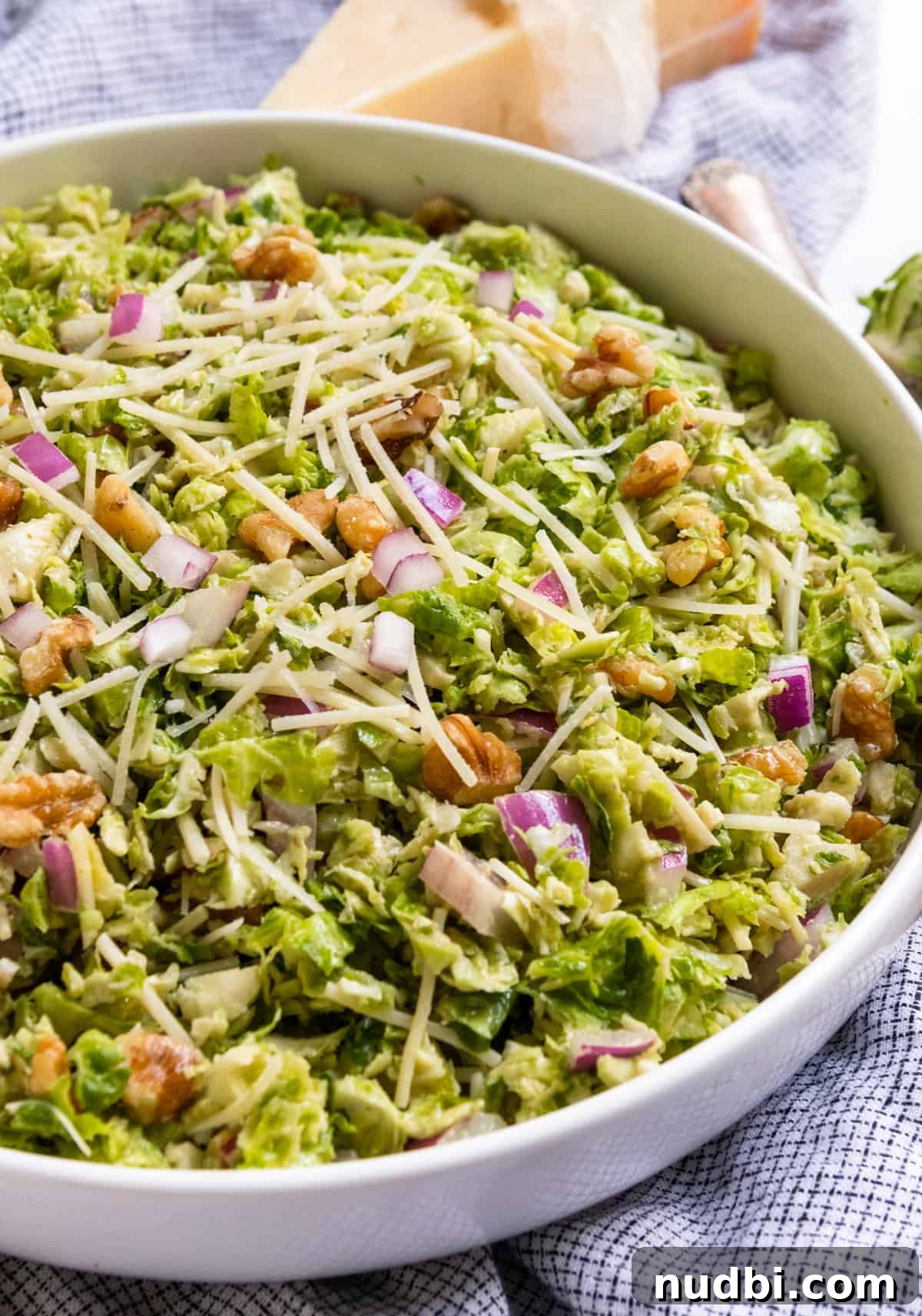 10 Refreshing Summer Salads and Sides for Your Next BBQ 7 Shaved Brussel Sprout Salad in white bowl with shredded parmesan.