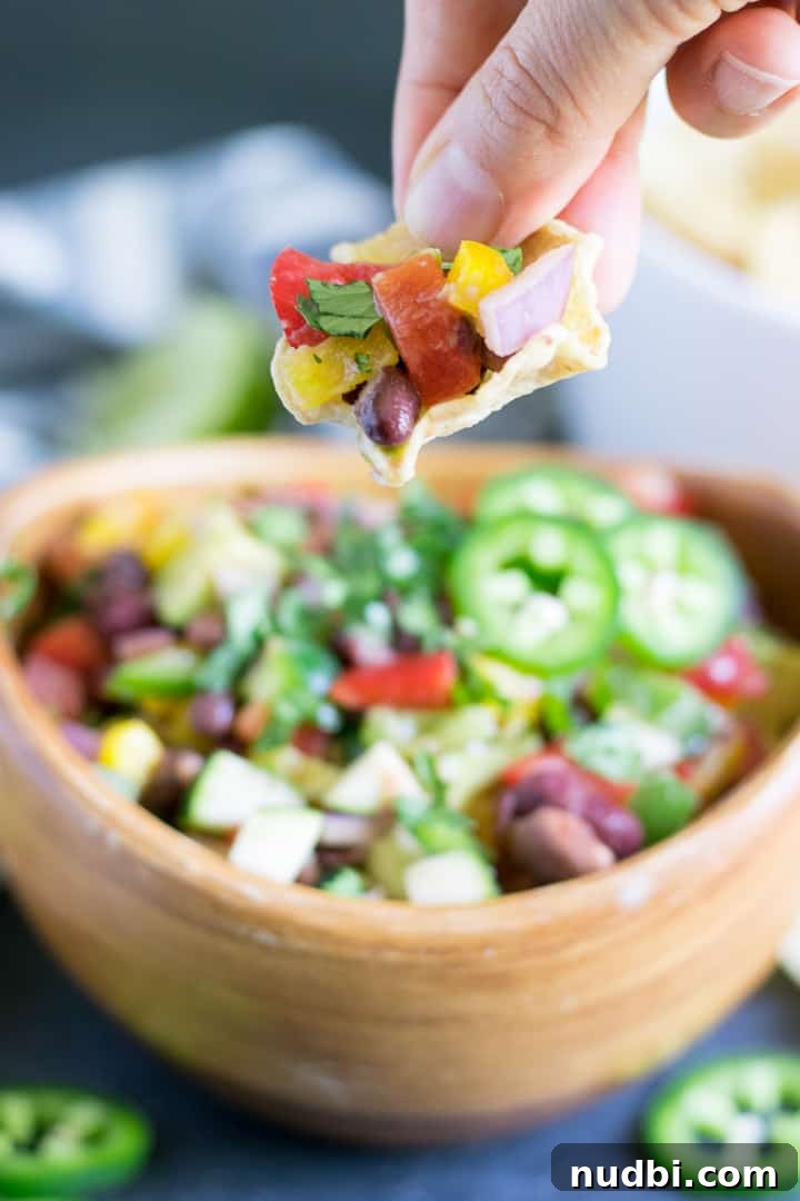 10 Refreshing Summer Salads and Sides for Your Next BBQ 8 Chip scooping up bean and veggie dip.