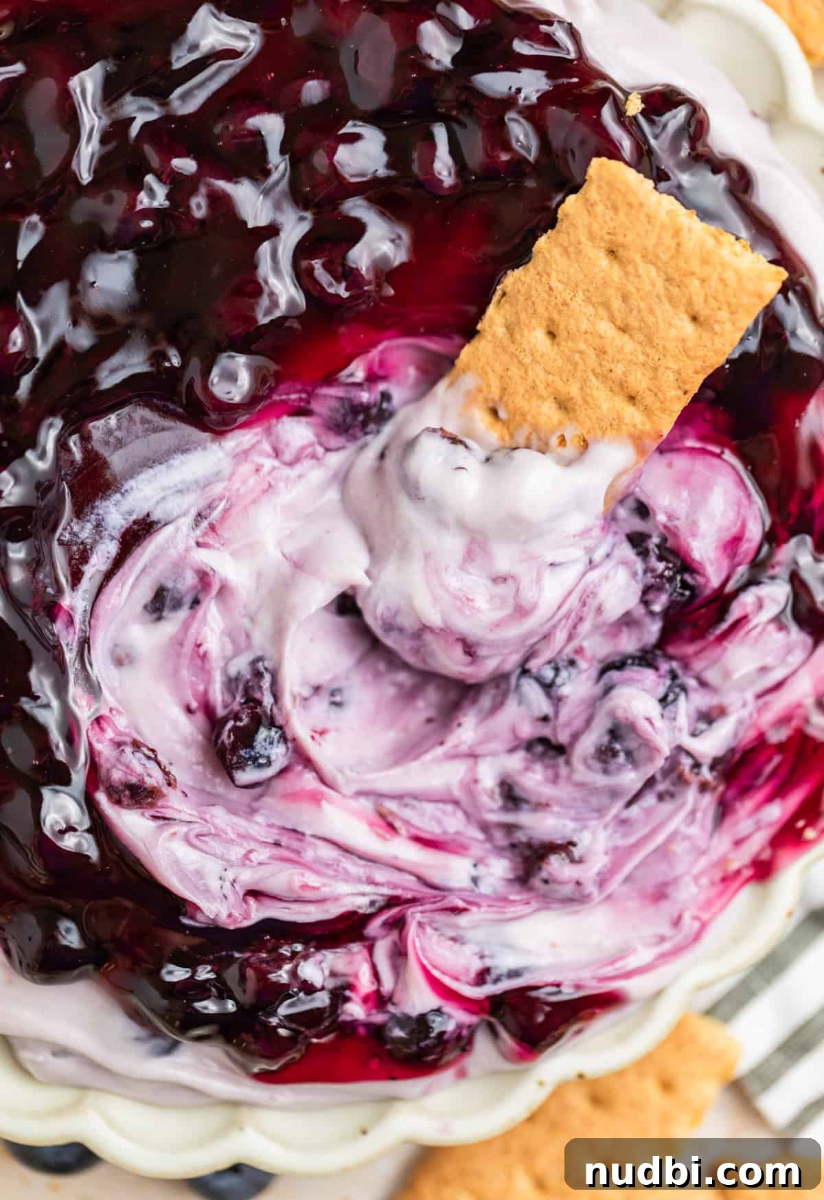 Creamy Blueberry Cheesecake Dip Recipe for Fruit & Crackers 2 Graham cracker dipped in blueberry cheesecake dip.