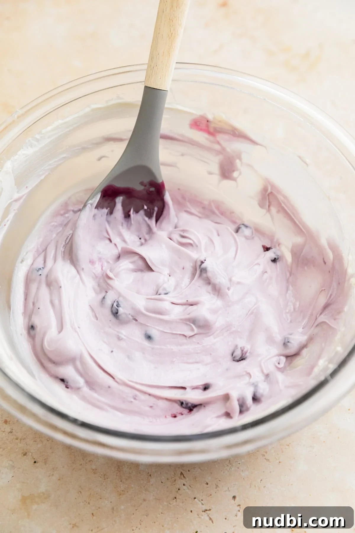 Creamy Blueberry Cheesecake Dip Recipe for Fruit & Crackers 7 Blueberry cheesecake dip in glass bowl with spoon.
