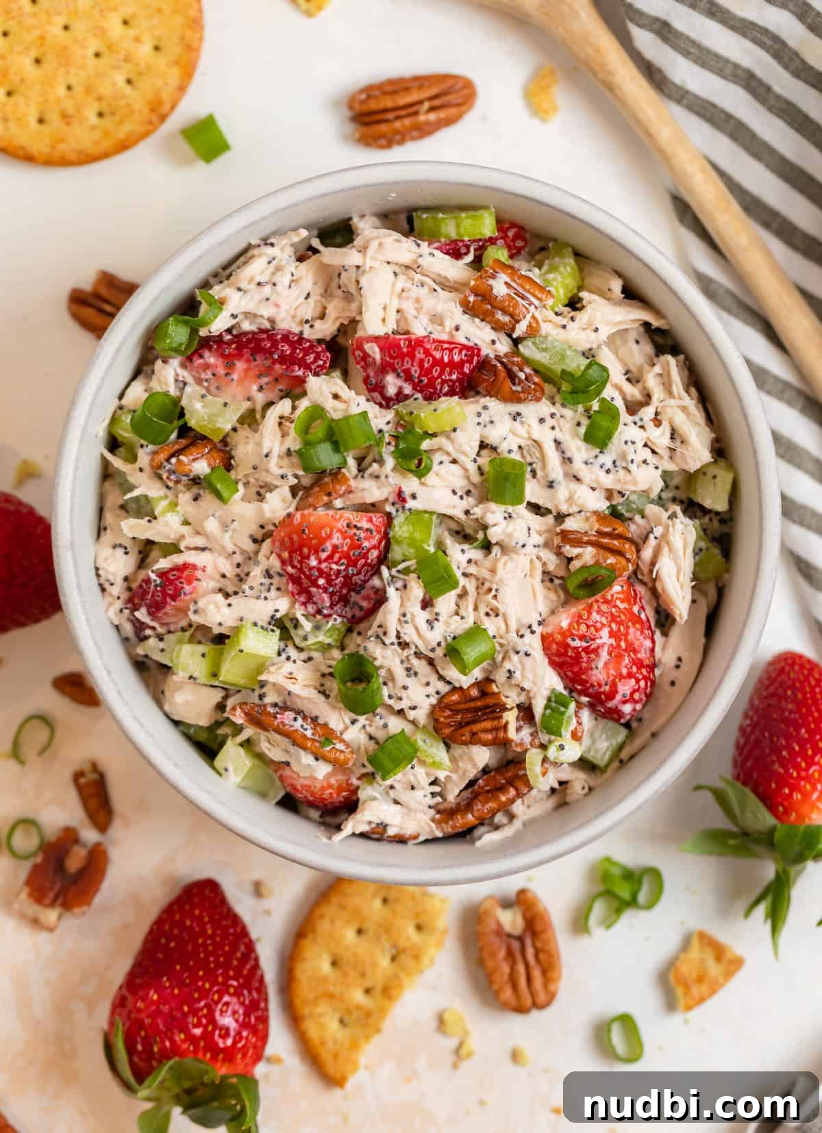 Strawberry Poppy Seed Chicken Salad with Pecans 3 Strawberry poppy seed pecan chicken salad in bowl with crackers and strawberries surrounding.