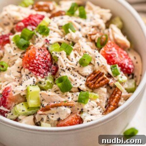 Strawberry Poppy Seed Chicken Salad with Pecans 8 White bowl with strawberry pecan chicken salad topped with green onion and pecans.