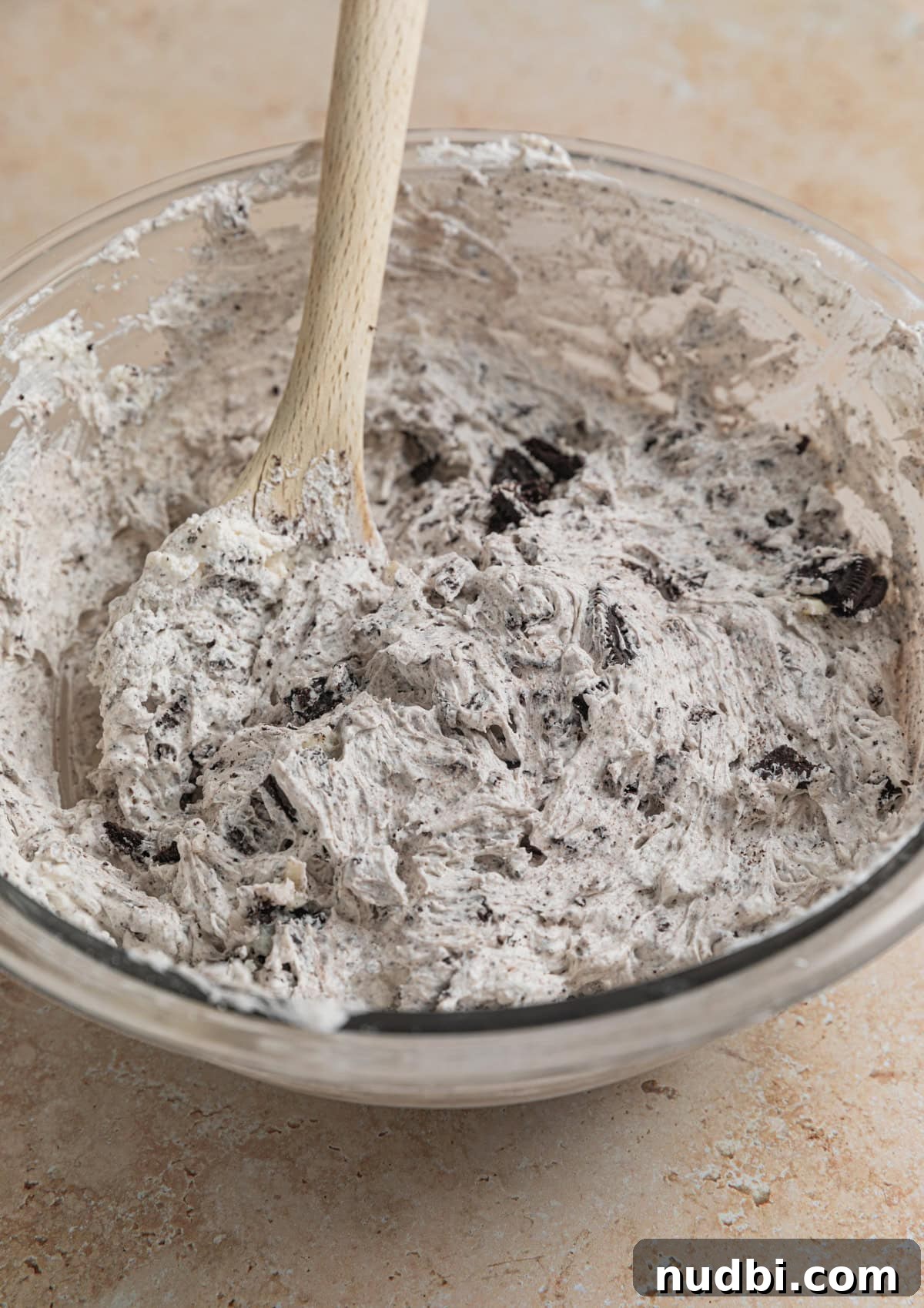 No-Bake Oreo Cheesecake Cups Recipe for Creamy Dessert 11 No bake Oreo cheesecake filling in bowl with spoon.