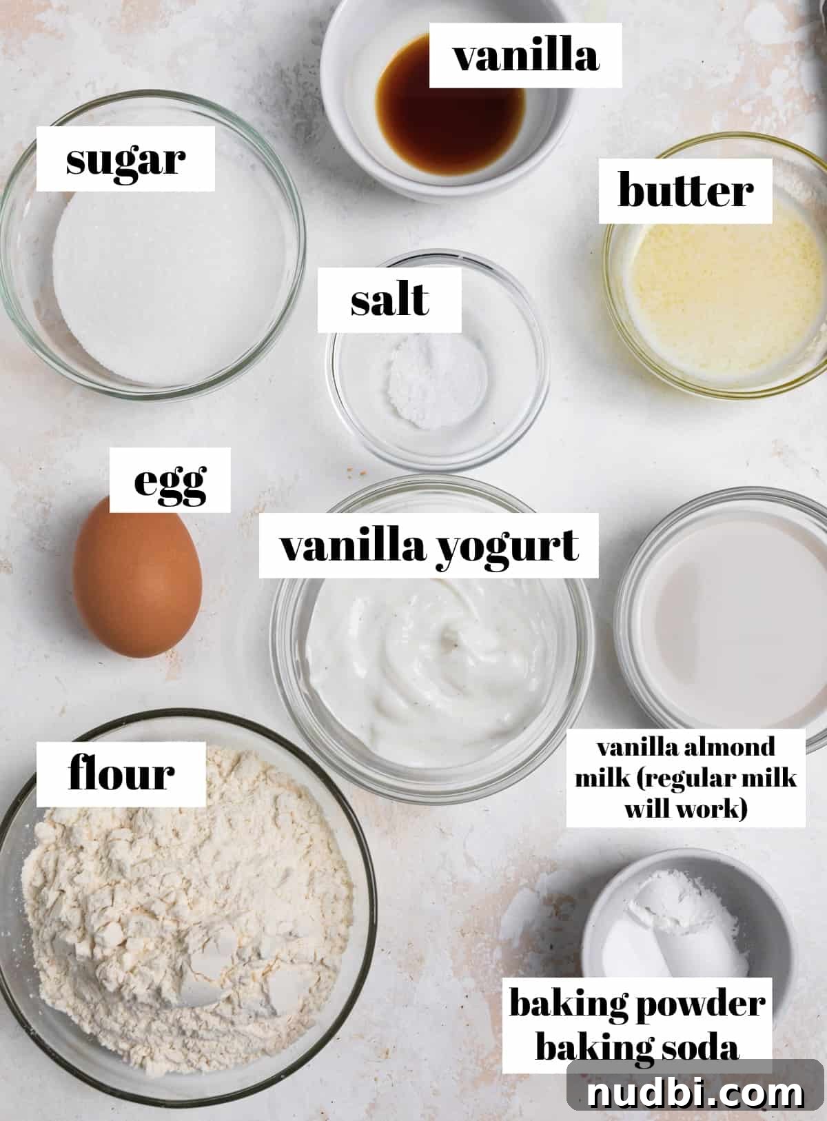 Triple Vanilla Donuts Recipe: Soft, Fluffy, and Extra Vanilla 3 Flour, yogurt, baking powder, butter and other recipe ingredients labeled on a counter.