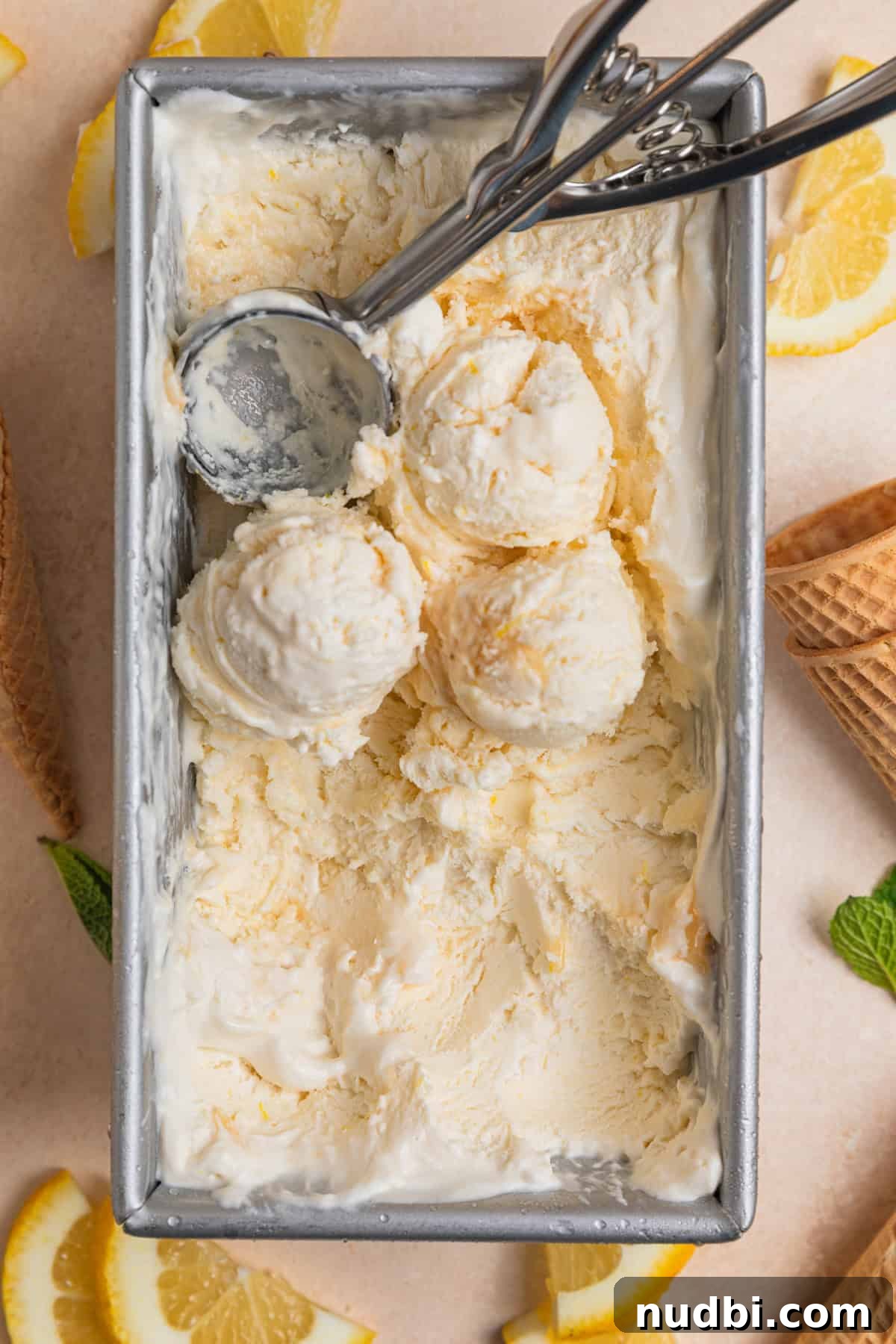 No-Churn Lemon Ice Cream Recipe — Creamy, Tart & Refreshing 11 Overhead view of bread pan with scooped lemon ice cream.