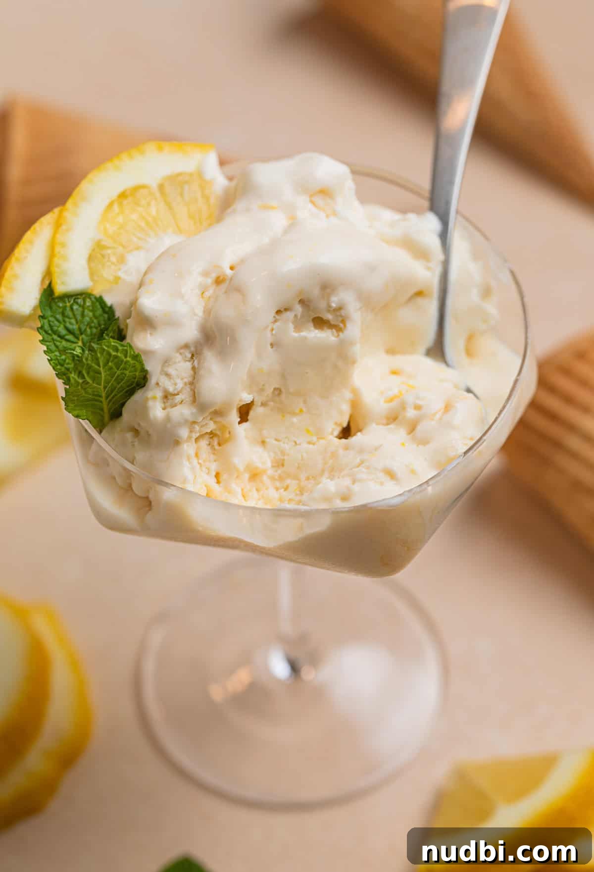 No-Churn Lemon Ice Cream Recipe — Creamy, Tart & Refreshing 3 Dish with half of a serving of lemon ice cream and spoon placed in the dish.