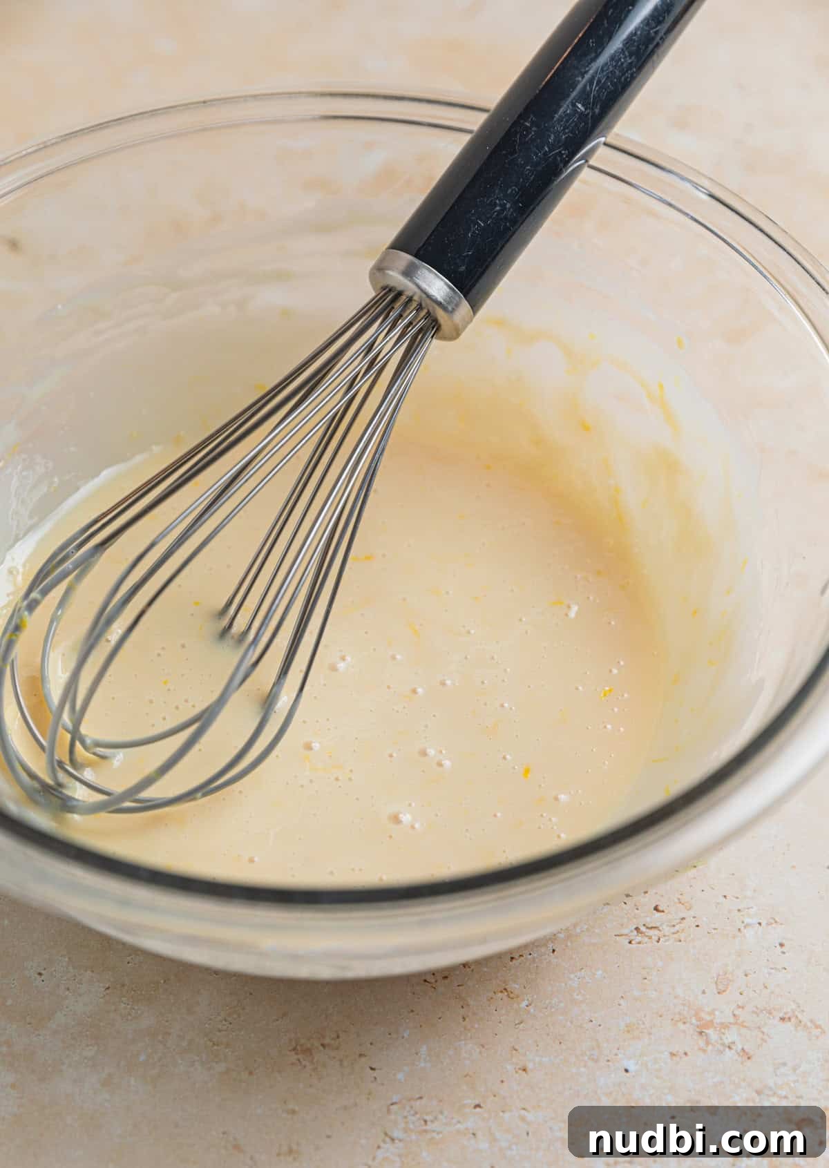 No-Churn Lemon Ice Cream Recipe — Creamy, Tart & Refreshing 4 Sweetened condensed milk, lemon zest, lemon juice and vanilla whisked together in glass bowl with whisk propped in the bowl.