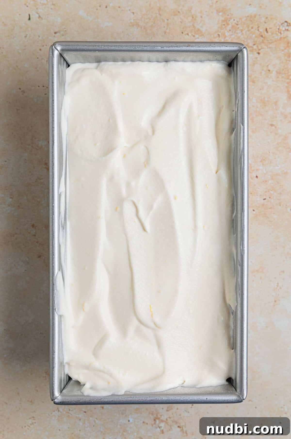 No-Churn Lemon Ice Cream Recipe — Creamy, Tart & Refreshing 8 Bread pan with lemon ice cream mixture before freezing.