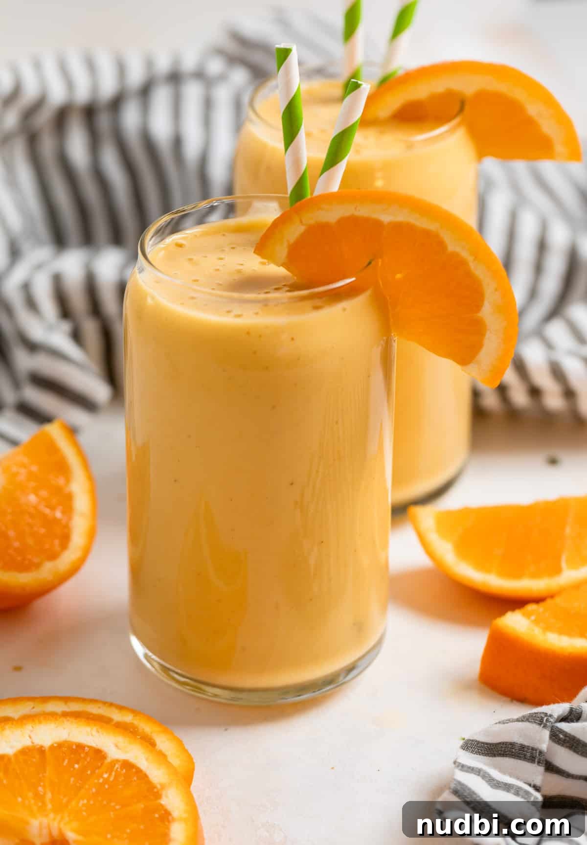 Orange Creamsicle Protein Smoothie Recipe for Creamy Vitamin C Boost 4 Orange creamsicle smoothies in glass cups with orange slice garnish.
