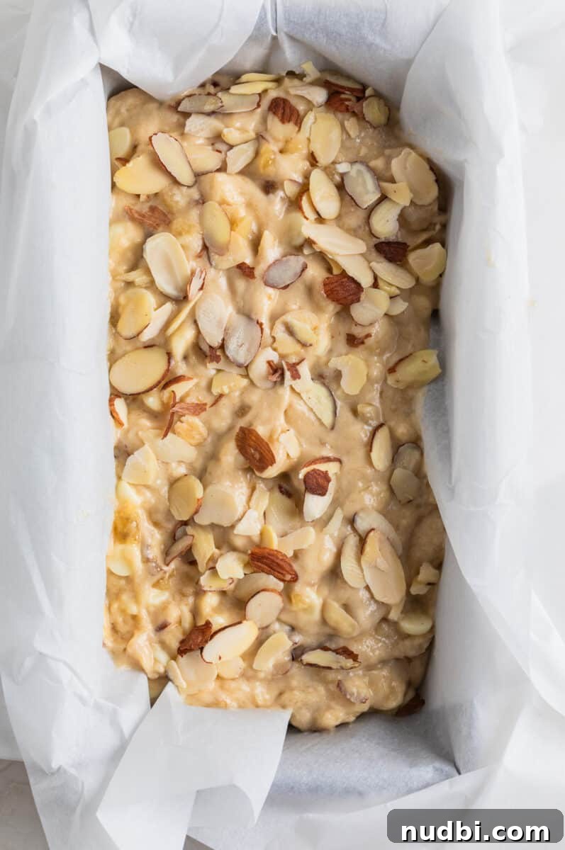 White Chocolate and Almond Banana Bread Recipe 5 White chocolate chip banana bread batter in parchment lined bread pan.