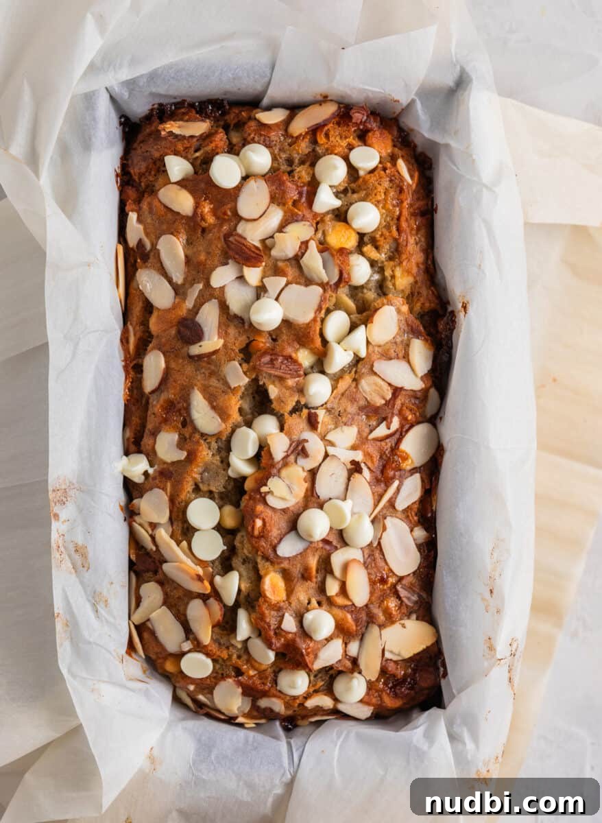 White Chocolate and Almond Banana Bread Recipe 6 Baked banana bread in bread pan with sliced almonds and white chocolate chips on top