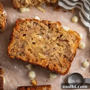 White Chocolate and Almond Banana Bread Recipe 8 Banana bread slice with white chocolate chips and other slices surrounding.