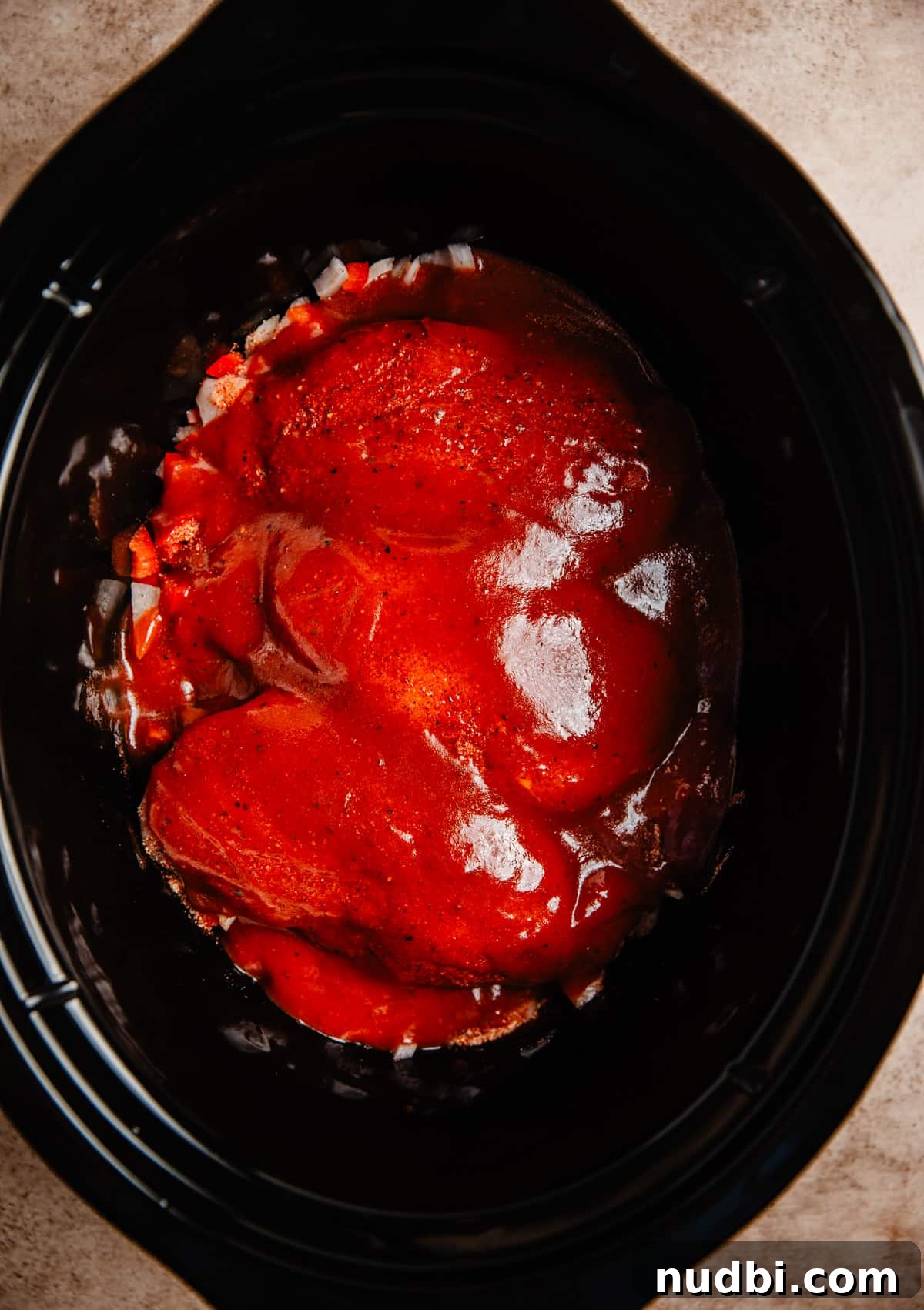 Slow Cooker BBQ Shredded Chicken Recipe for Sandwiches and Tacos 5 BBQ sauce over top of chicken in slow cooker.