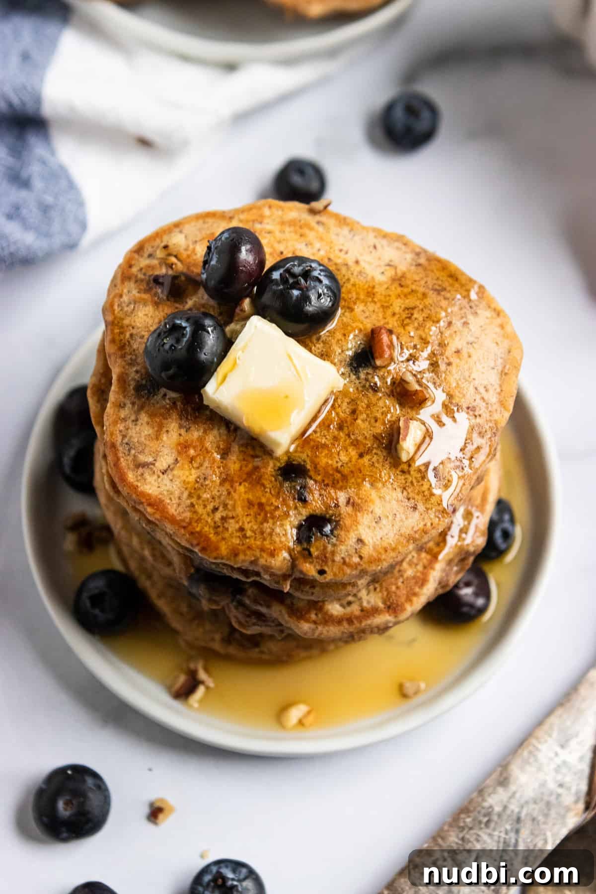 Whole Wheat Blueberry Pancakes with Flaxseed (Fiber-Rich Recipe) 4 Close up of whole wheat flax pancakes on plate with butter and fresh berries.
