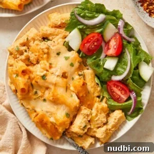 Creamy Pumpkin Ricotta Pasta Bake with Parmesan Crisp Topping 11 Pumpkin ricotta pasta on white plate with side salad and fork.