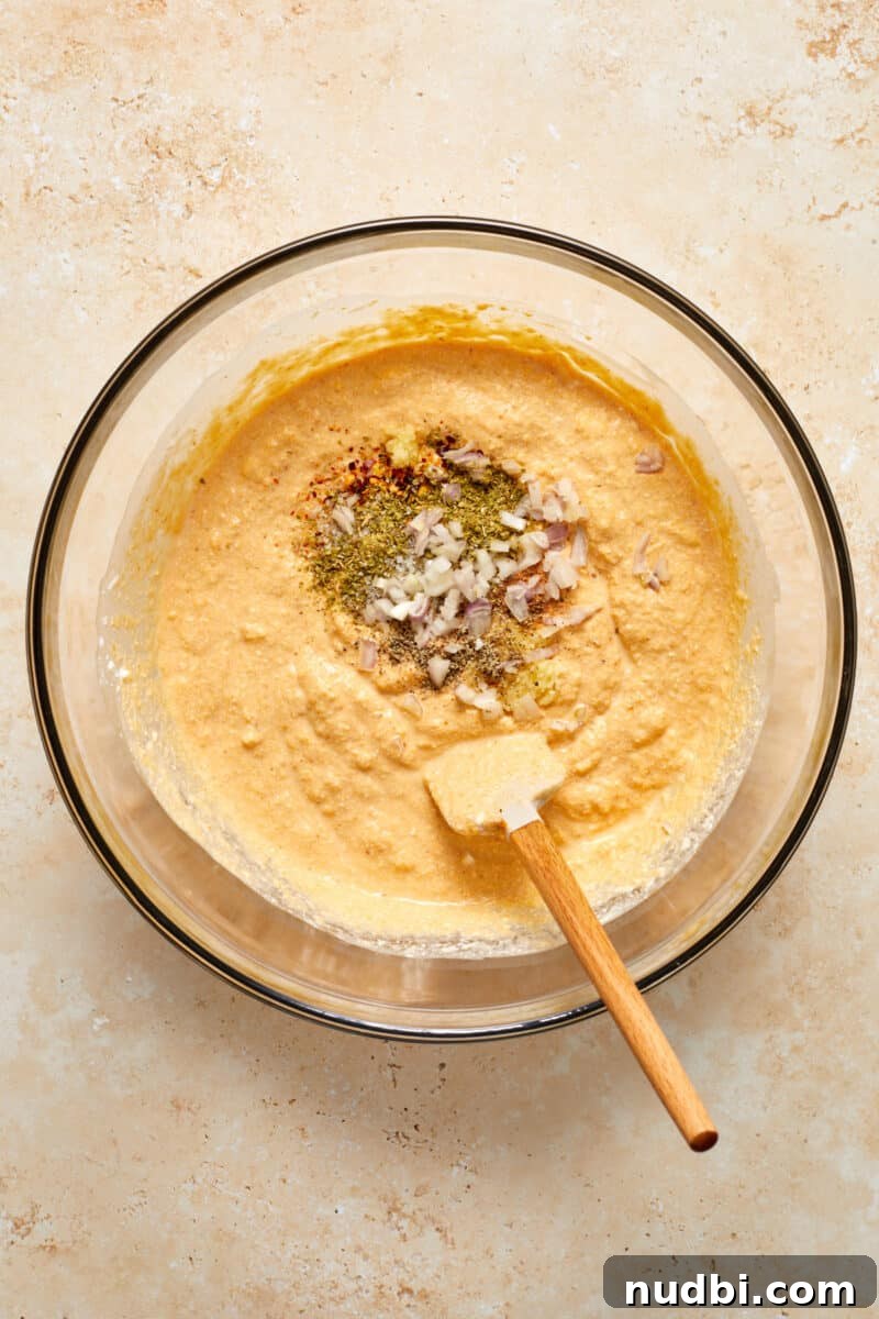 Creamy Pumpkin Ricotta Pasta Bake with Parmesan Crisp Topping 4 Pumpkin ricotta mixture in mixing bowl with shallot and seasoning on top.