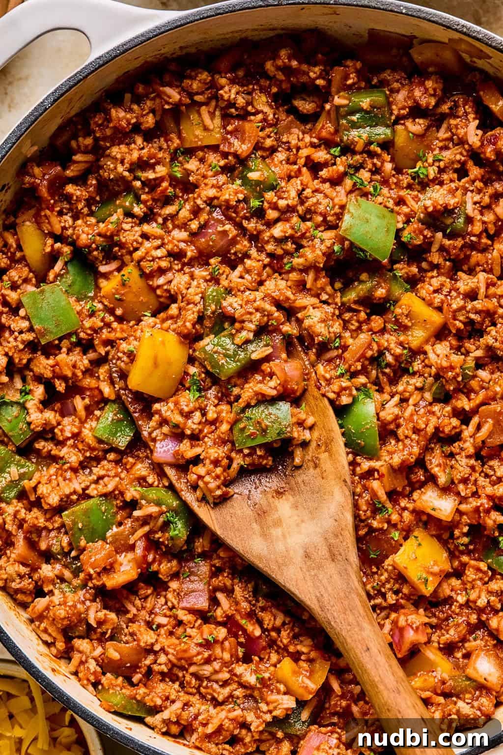 Weeknight Ground Turkey Skillet Dinner Recipe 2 Skillet with ground turkey and pepper dinner with rice and wooden spoon scooping in.